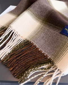 Close-up of classic plaid scarf texture with long tassels and soft cashmere-like fabric