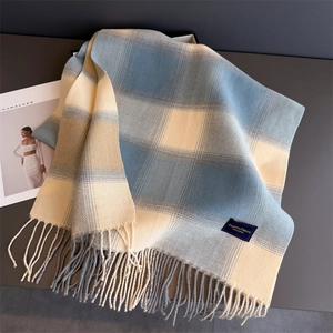 Detail of plaid scarf featuring blue and beige checkered pattern with long tassels