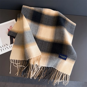 Detailed view of the soft cashmere-like texture and tassel edges of the plaid scarf