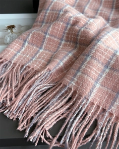 Detailed macro view of pink and white plaid cashmere-like scarf with soft fringe edges