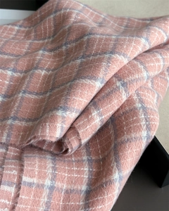 Close-up of soft pink and beige plaid texture on thick winter cashmere-like scarf
