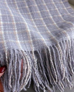 Detail of purple plaid cashmere scarf showing soft fabric texture and fringe trim
