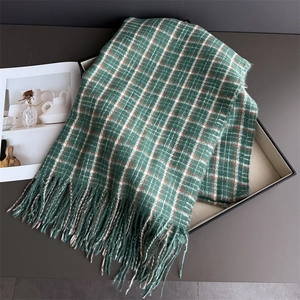 Detail of vintage green plaid cashmere-feel scarf featuring soft fringe and thick texture