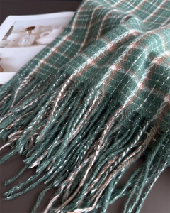 Close-up of mint green plaid scarf featuring soft texture and decorative long tassels
