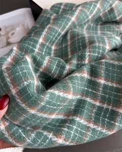 Close-up of green and white plaid scarf fabric with soft brushed cashmere texture