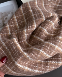 Macro shot of thick brown plaid scarf texture showing soft brushed cashmere-like fibers