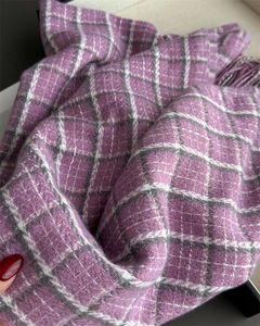 Close-up of purple and white plaid scarf featuring thick tassels and soft knit texture