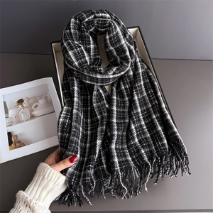 Detail of soft black and white plaid scarf with fringe tassels in a luxury gift box