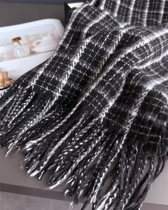 Macro shot of thick black and white plaid scarf fabric with fringe detail