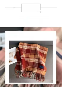 Detail of red-brown checkered scarf featuring long fringe and soft polyester texture