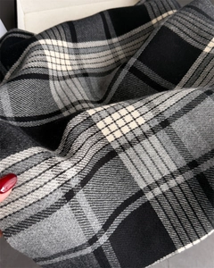 Close-up of soft black and grey plaid cashmere-like fabric with detailed woven texture