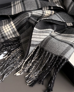 Detailed view of the soft plaid cashmere-feel scarf texture with fringe accents