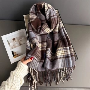 Close-up of soft plaid cashmere scarf with hand-tied tassels in brown and grey tones