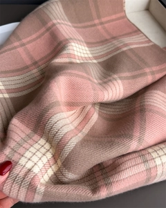 Detail of soft plaid cashmere-like scarf showing warm pink, beige, and khaki check pattern