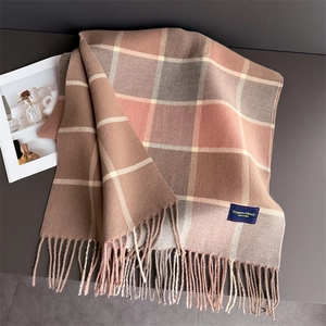 Detail of plaid scarf featuring fringe edges and retro pattern on a dark background