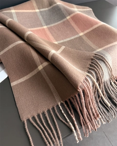 Detail of warm checkered scarf showing soft cashmere texture and fine fringe tassels