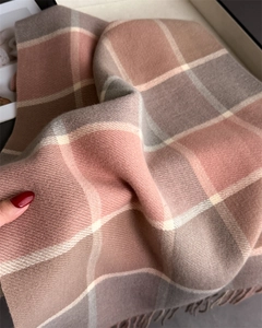 Close-up of soft plaid cashmere scarf with pink and brown fringe and woven texture