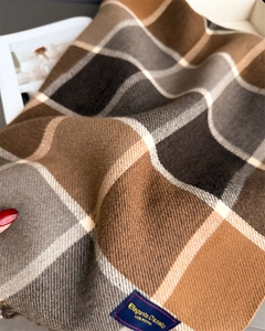 Close-up of classic checkered cashmere-style scarf with elegant brand label and fringe