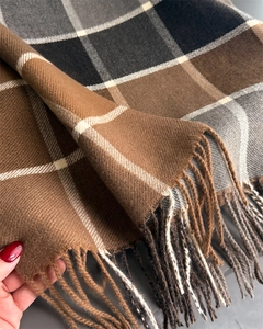 Detail shot of warm brown and grey plaid cashmere-like scarf with fringe accents