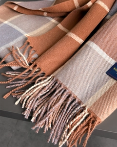 Close-up of caramel and beige plaid scarf with soft tassels and twill texture detail
