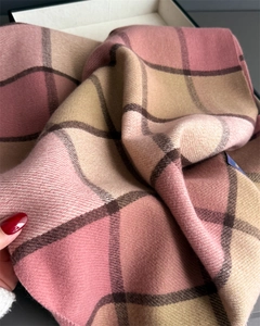 Close-up of soft tassel scarf with classic pink and beige plaid cashmere texture