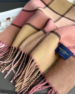 Close-up of pink and brown plaid cashmere scarf featuring fine fringe and elegant label