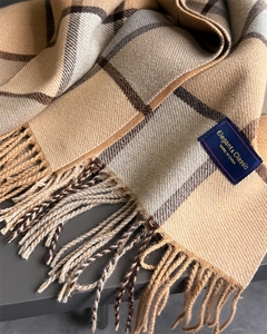 Close-up of soft plaid scarf with fringe tassels and elegant woven brand label
