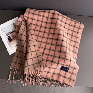 Detail of pink plaid cashmere scarf showing soft texture, fringes and elegance tag
