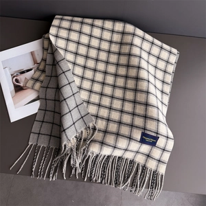 Detailed view of the plaid knit texture and soft fringe on the autumn winter shawl