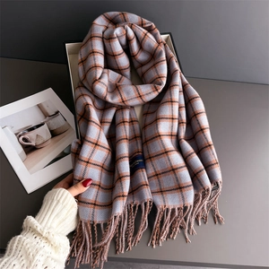 Close-up of grey and blue plaid scarf with orange accents and fine fringe details