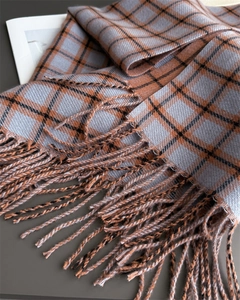 Close-up of retro plaid scarf with soft fringe tassels and classic earth-tone patterns