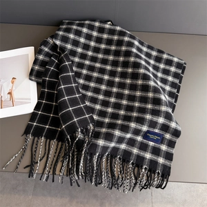 Detail of black and white plaid scarf with fringe and Elegant Classic fabric label