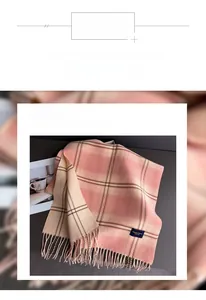 Detail of pink and beige plaid scarf showing soft polyester texture and fringe tassels