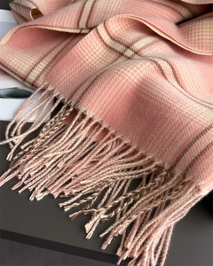 Close-up of pink plaid cashmere-like scarf showing soft texture and tassel detail