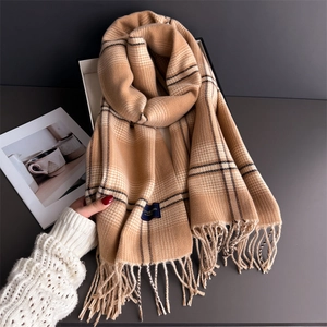 Classic camel plaid scarf with tassels on a gift box, cozy autumn winter accessory