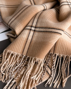 Close-up of soft plaid scarf featuring beige and brown tassels and twill weave texture