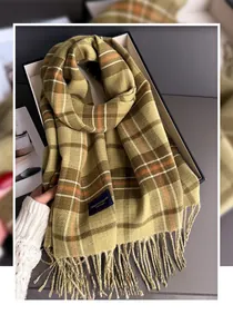 Vue détaillée d'une écharpe à carreaux style cachemire vert olive avec de fins glands
