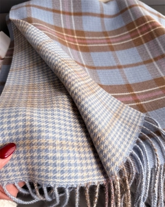 Gros plan d'une écharpe à carreaux style cachemire avec texture douce et franges