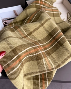 Détail du tissu de l'écharpe à carreaux montrant une texture douce et franges