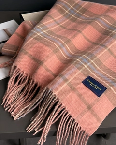Détail de l'écharpe à carreaux rose avec étiquette tissée élégante et franges souples