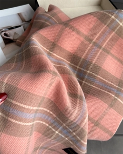 Détail de la texture d'une écharpe en cachemire à carreaux classiques rose et bleu
