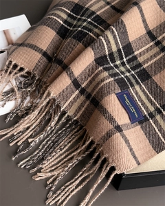 Détail de la texture d'écharpe à carreaux beige avec franges et étiquette tissée