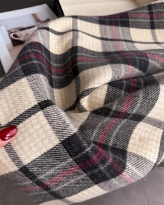 Gros plan sur le tissu d'une écharpe à carreaux classique beige, noir et bordeaux