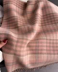 Close-up of pink and brown plaid scarf with thick fringe and soft brushed texture