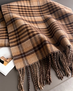 Close-up of brown and caramel plaid scarf with fringe details and soft wool texture