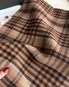 Close-up of thick brown plaid scarf texture showing soft hand-feel and wool-like fabric