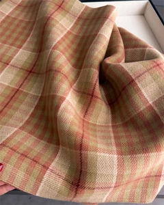 Macro detail of retro plaid scarf with soft woven fiber texture in a premium gift box