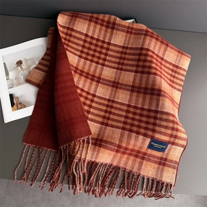 Detailed view of vintage plaid scarf texture with tassels and elegant fabric label