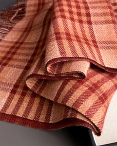 Close-up of orange plaid cashmere scarf showing thick texture and tassel fringe detail