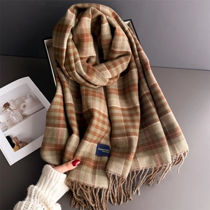 Classic British plaid cashmere scarf with soft fringes shown in a stylish studio setup